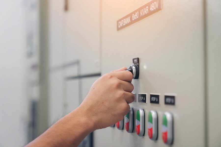 Electrical engineer man checking voltage and test at the Power Distribution Cabinet in the control room, preventive maintenance Yearly